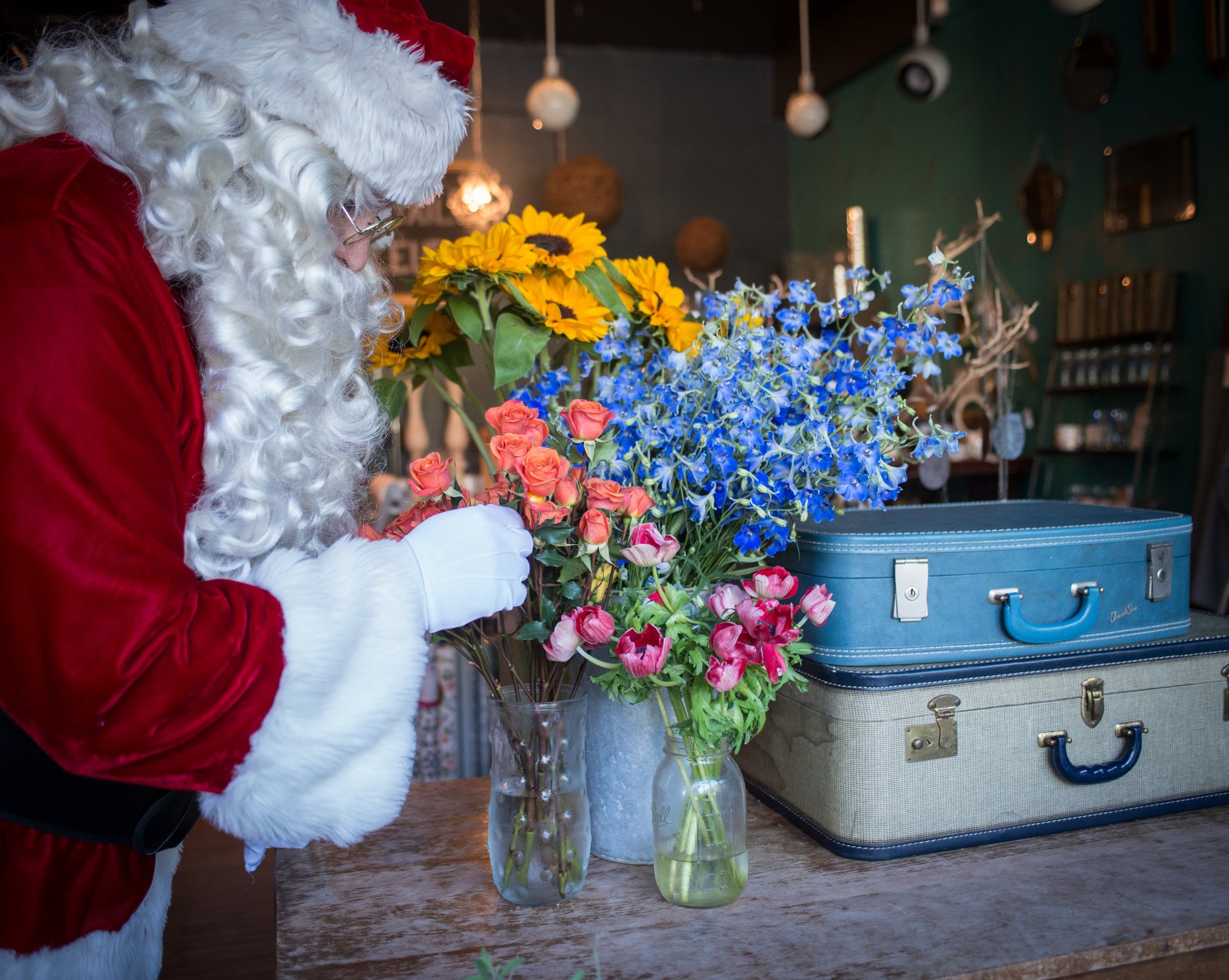 Santa with flowers and vintage suitcases at Fleur, a Logan Square florist