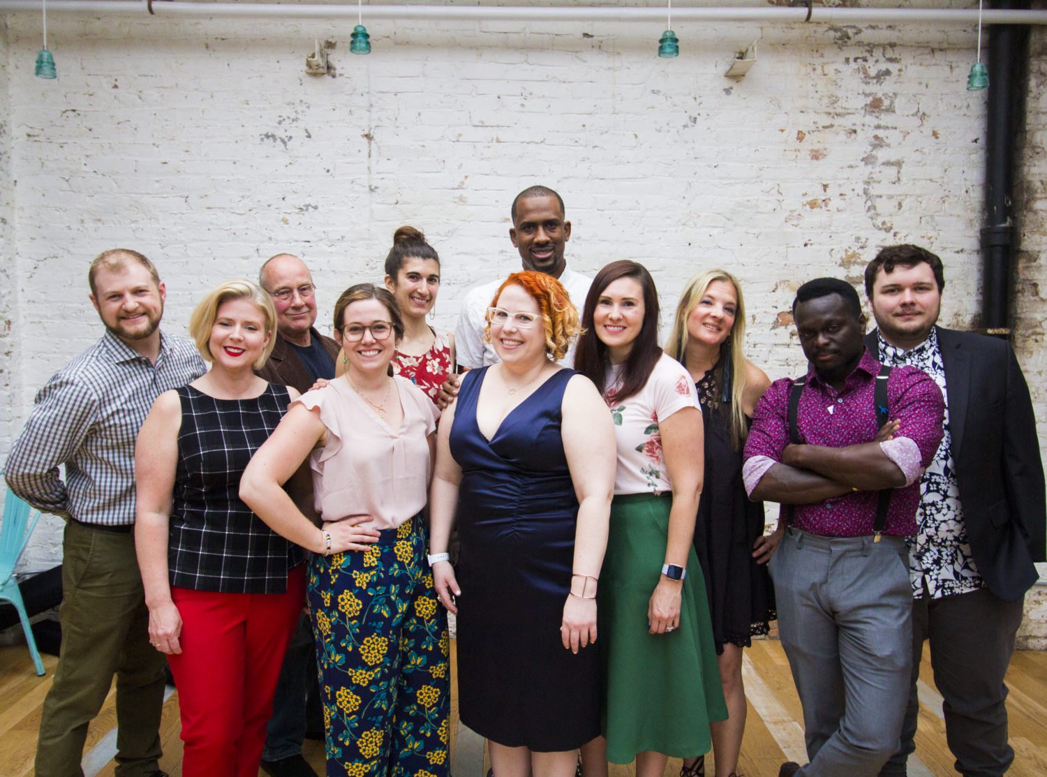 The LoganSquarist team in 2019, with Kate Hamilton at center, against a white brick wall