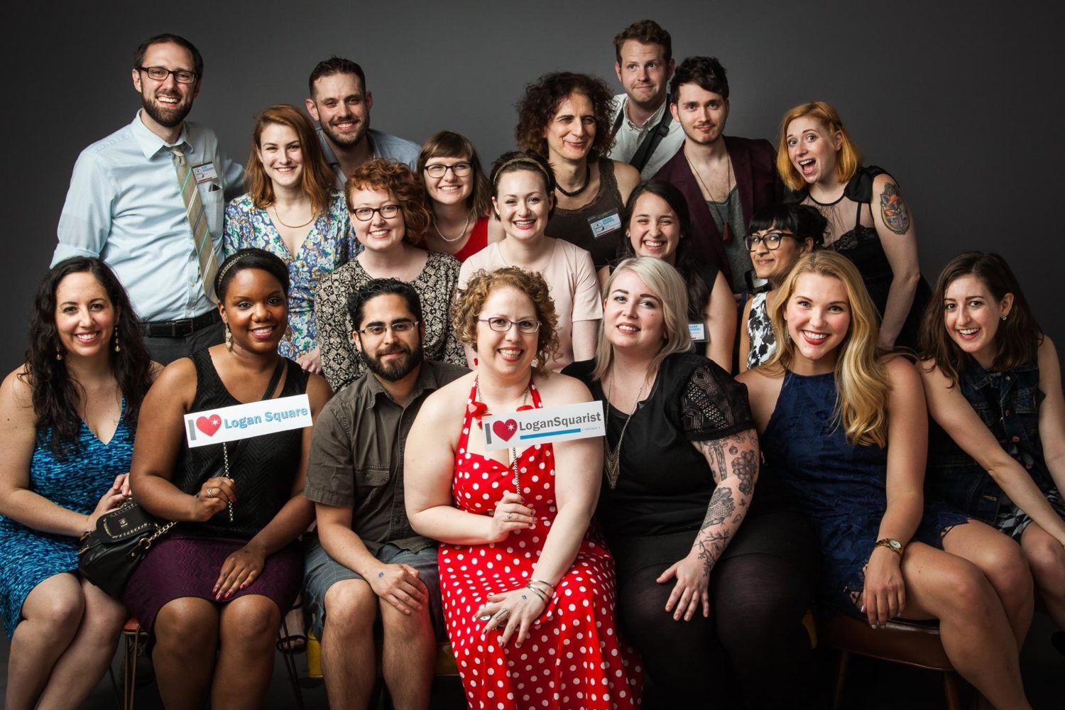 The 2016 LoganSquarist team in a studio portrait, with Kate Hamilton holding an I love LoganSquarist sign