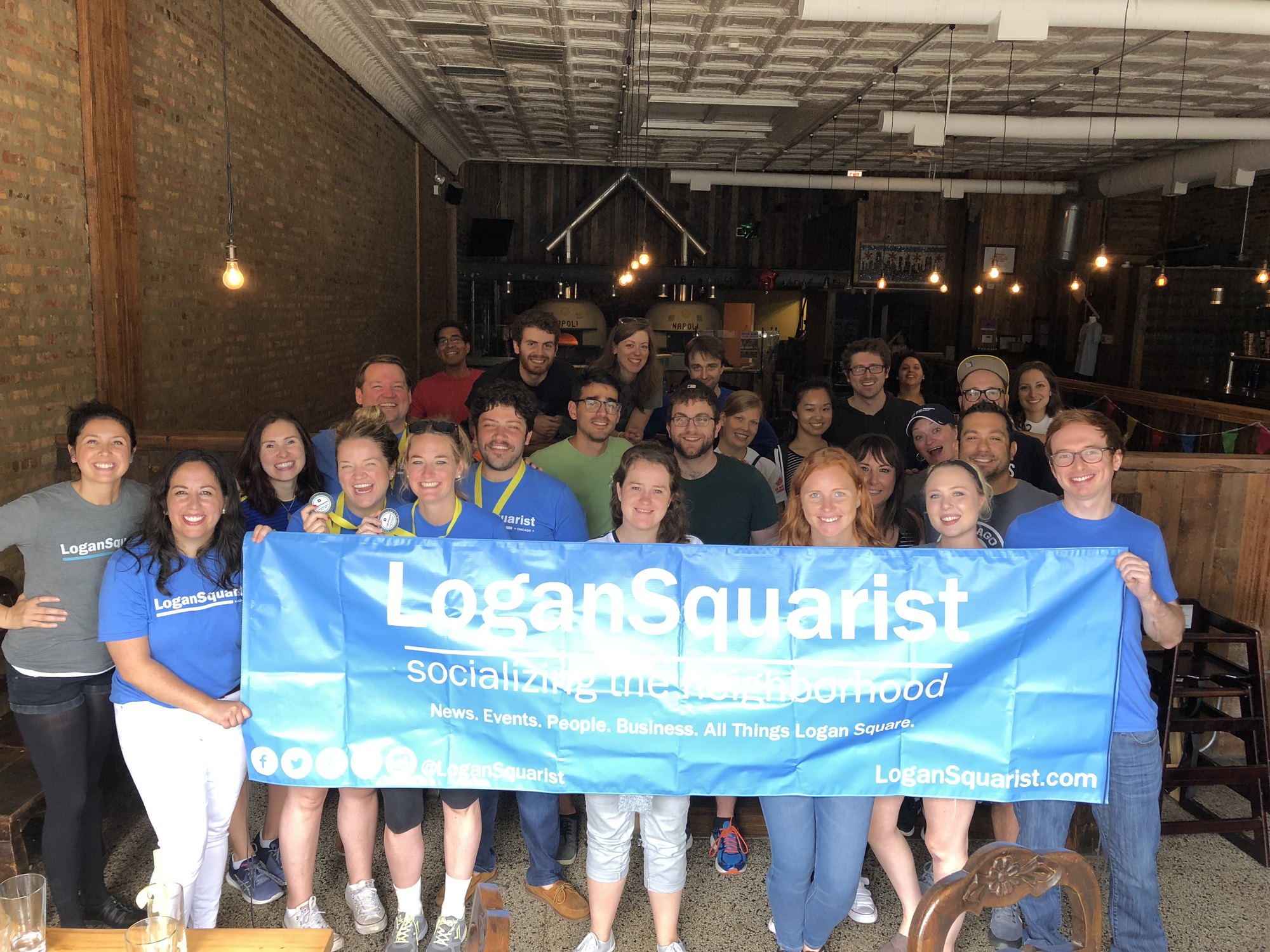 Amazing Race players holding the LoganSquarist banner at the 2018 finish line