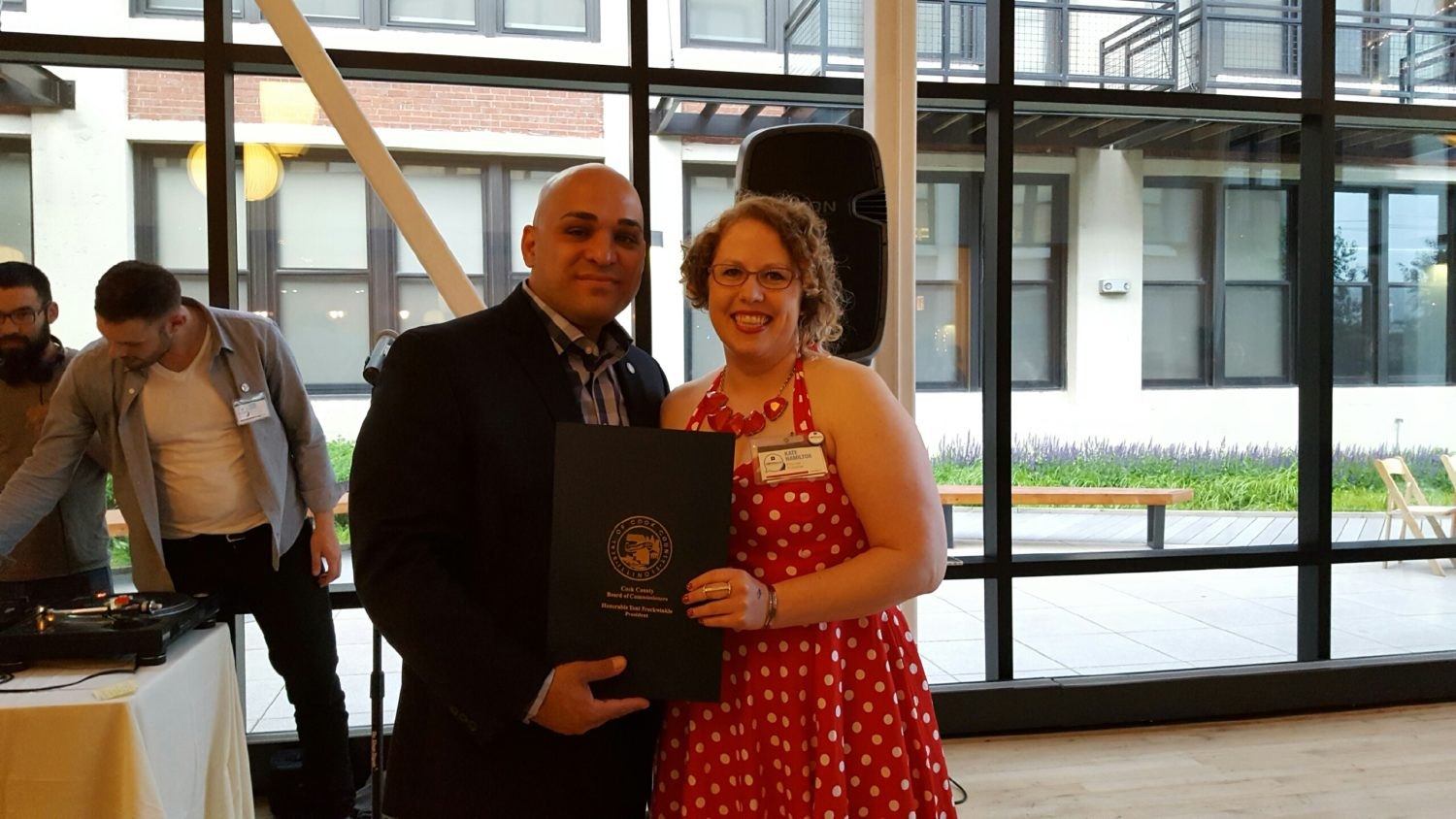 Kate Hamilton accepting a framed resolution for LoganSquarist's fifth anniversary