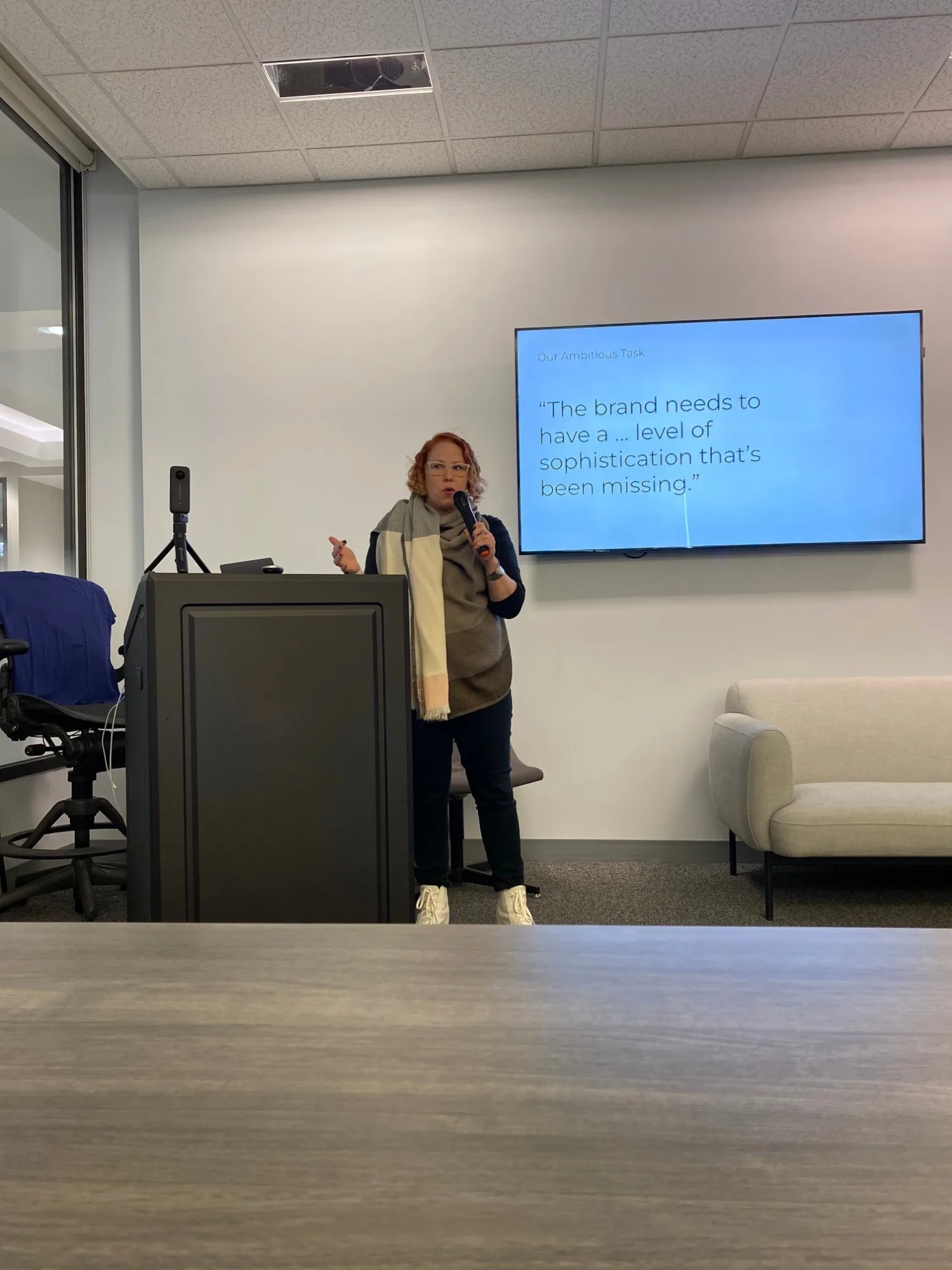 Kate Hamilton speaking at a podium in front of a slide