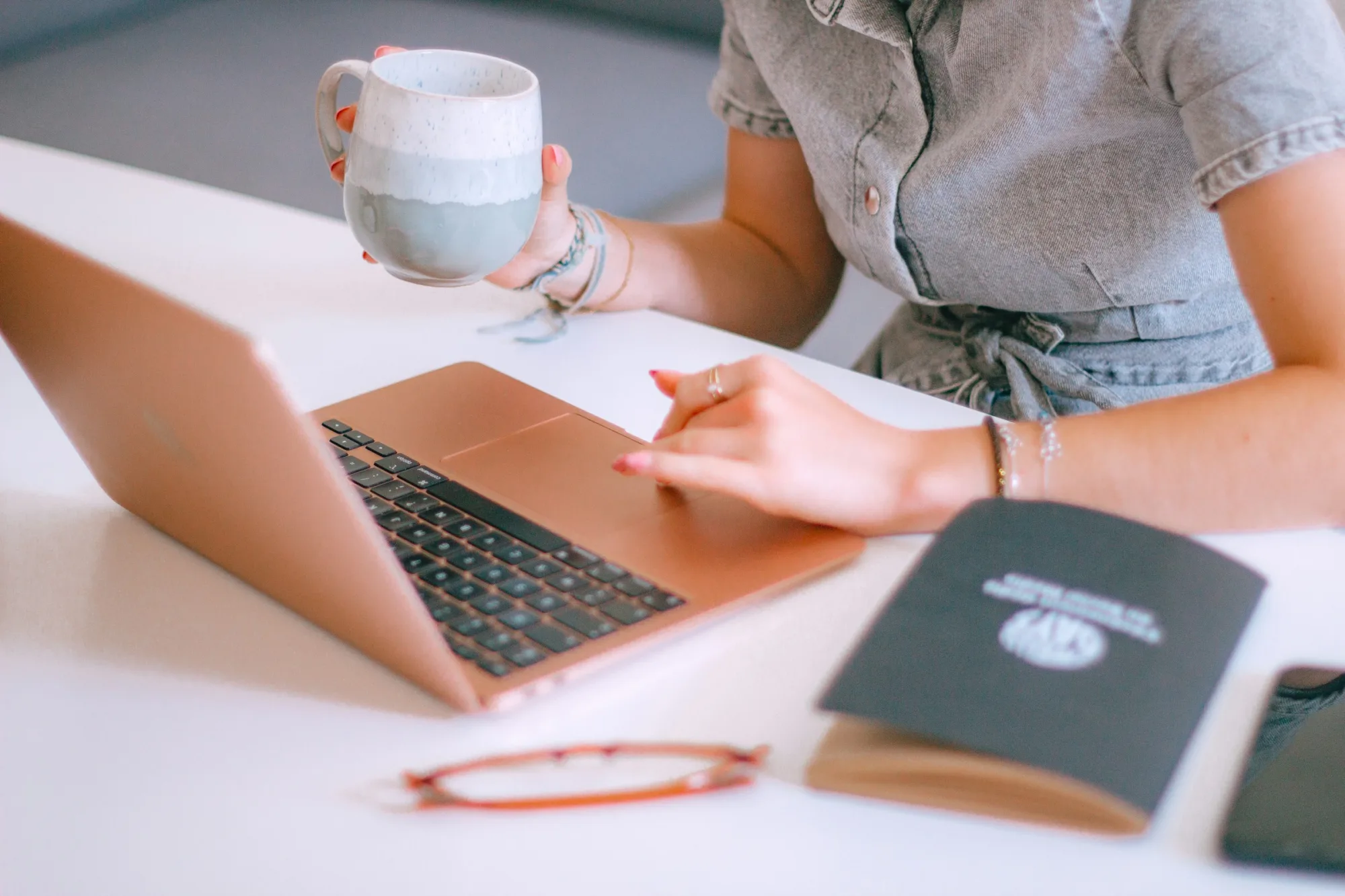 A marketing leader pauses at her laptop with coffee in hand—the moment the dashboard becomes a decision.