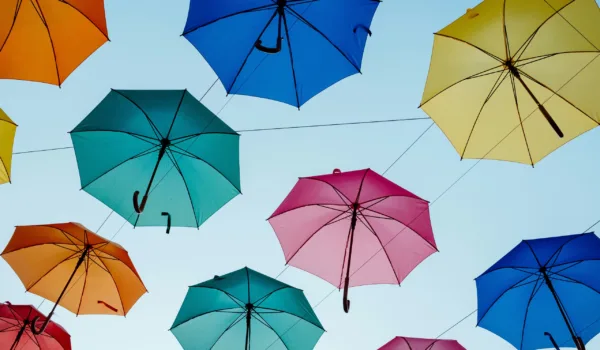 Overhead view of coordinated umbrellas arranged together, representing alignment and shared direction across teams.